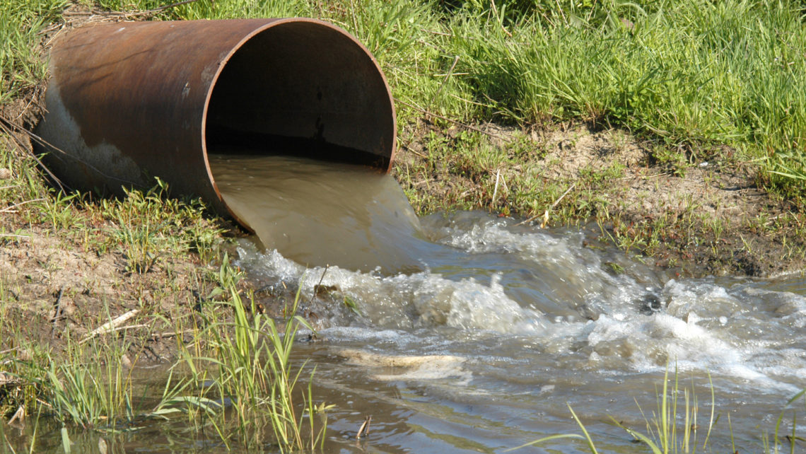 Industrial wastewater outfall in grassy swale or pond