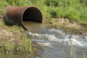 Industrial wastewater outfall in grassy swale or pond