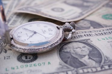 Pocket watch on a pile of money, representing time is money. Time spent on SPCC inspections saves money in the long run.