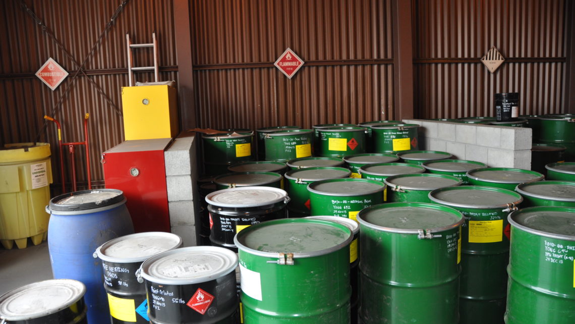Hazardous waste containers in a warehouse room