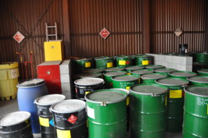 Hazardous waste containers in a warehouse room