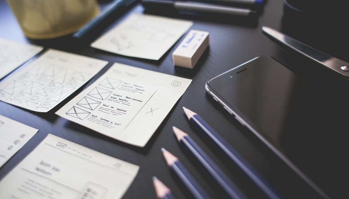 Pencils organized on a desk next to a phone, eraser, checklists, notes, and pens. The desk suggests testing and analysis consistent with the scientific method for an EHS manager.