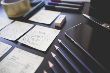 Pencils organized on a desk next to a phone, eraser, checklists, notes, and pens. The desk suggests testing and analysis consistent with the scientific method for an EHS manager.