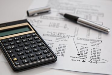 Calculator and pen on budget and investment calculations of cost increase