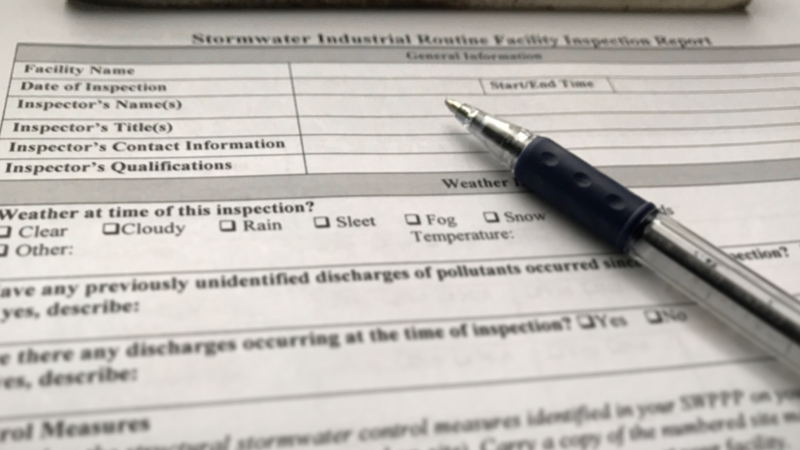 stormwater inspection checklist on clipboard with pen
