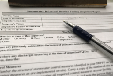 stormwater inspection checklist on clipboard with pen