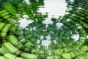 Water droplet caught in a green stone pond, creating a ripple effect