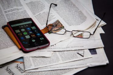 Newspapers, glasses, and phone splayed on a table indicated an attempt to keep up with EHS Blogs and news.